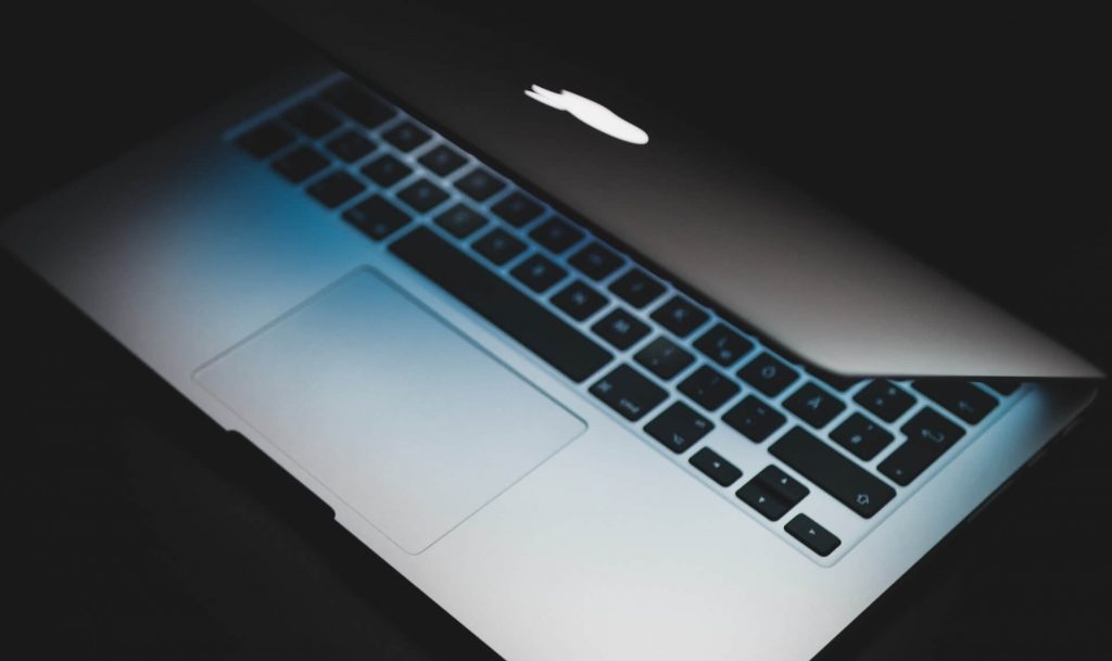 MacBook iluminado sobre un fondo oscuro